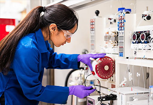 A PhD student works on the continuous-flow system at OASIS, where flexible tubes replace glass reaction vessels. Photograph by Jeff Liang