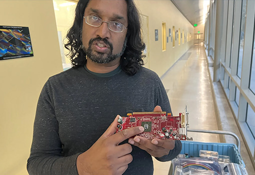 An image of Demis John, a scientist at UCSB's Nanofabrication Facility, shows the chip that acts as the brains of digital devices at UC Santa Barbara. 