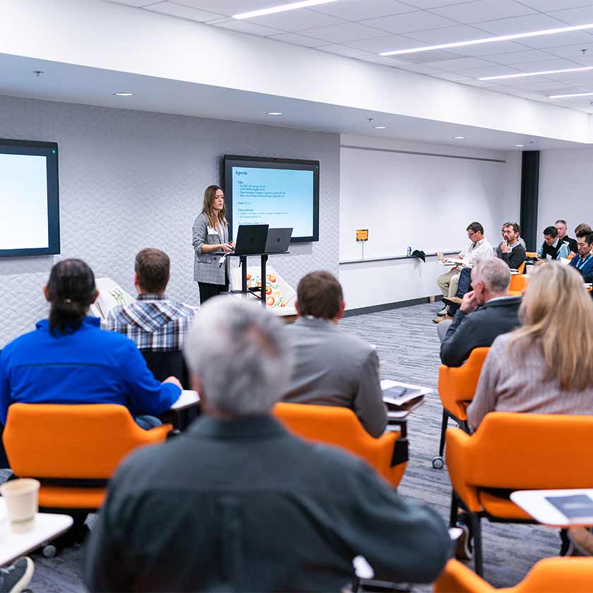 A person at a podium giving a talk in front of an audience