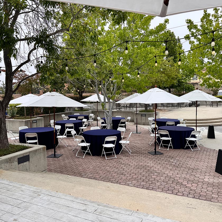 A patio with tables and umbrellas.